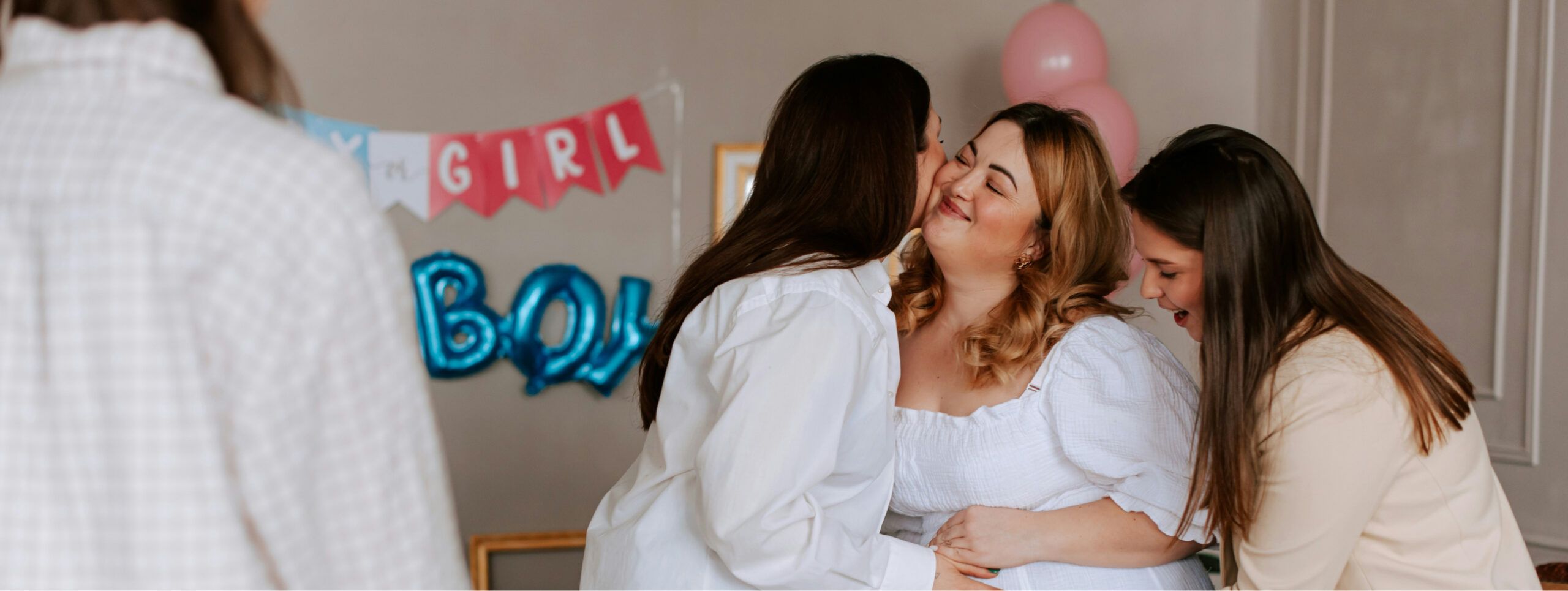 A group of women celebrating at a gender reveal party, with 