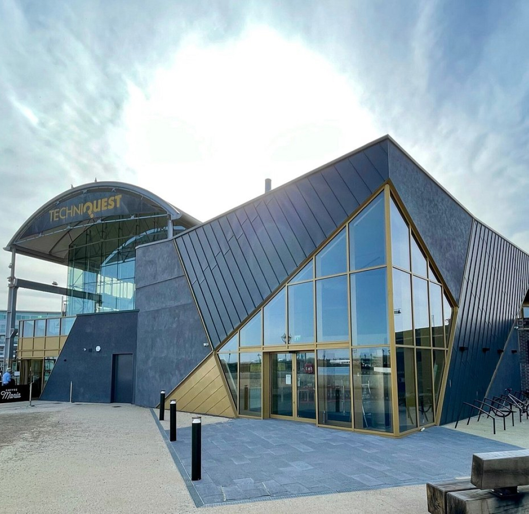 Modern building with angular design, large windows, and a branded sign reading 